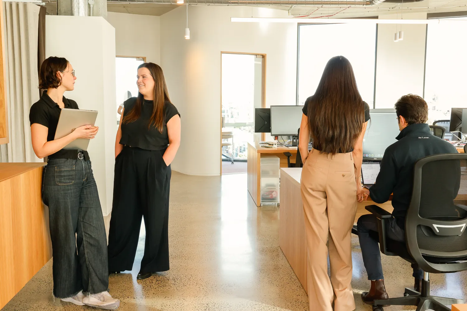 Four colleagues talking and working in the Customr office