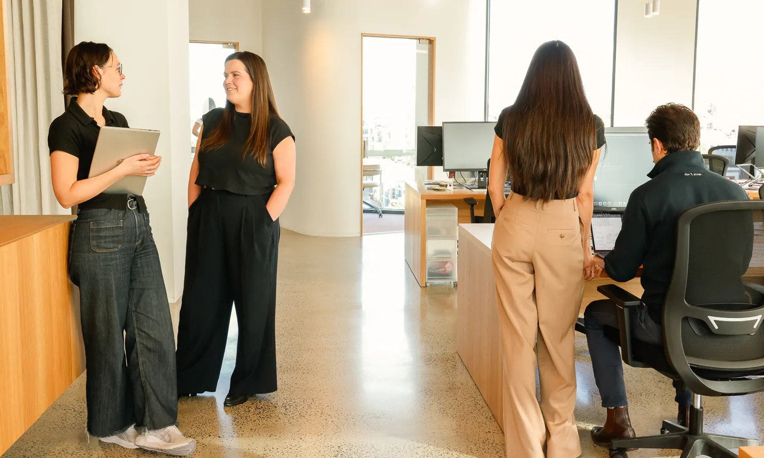Four colleagues talking and working in the Customr office
