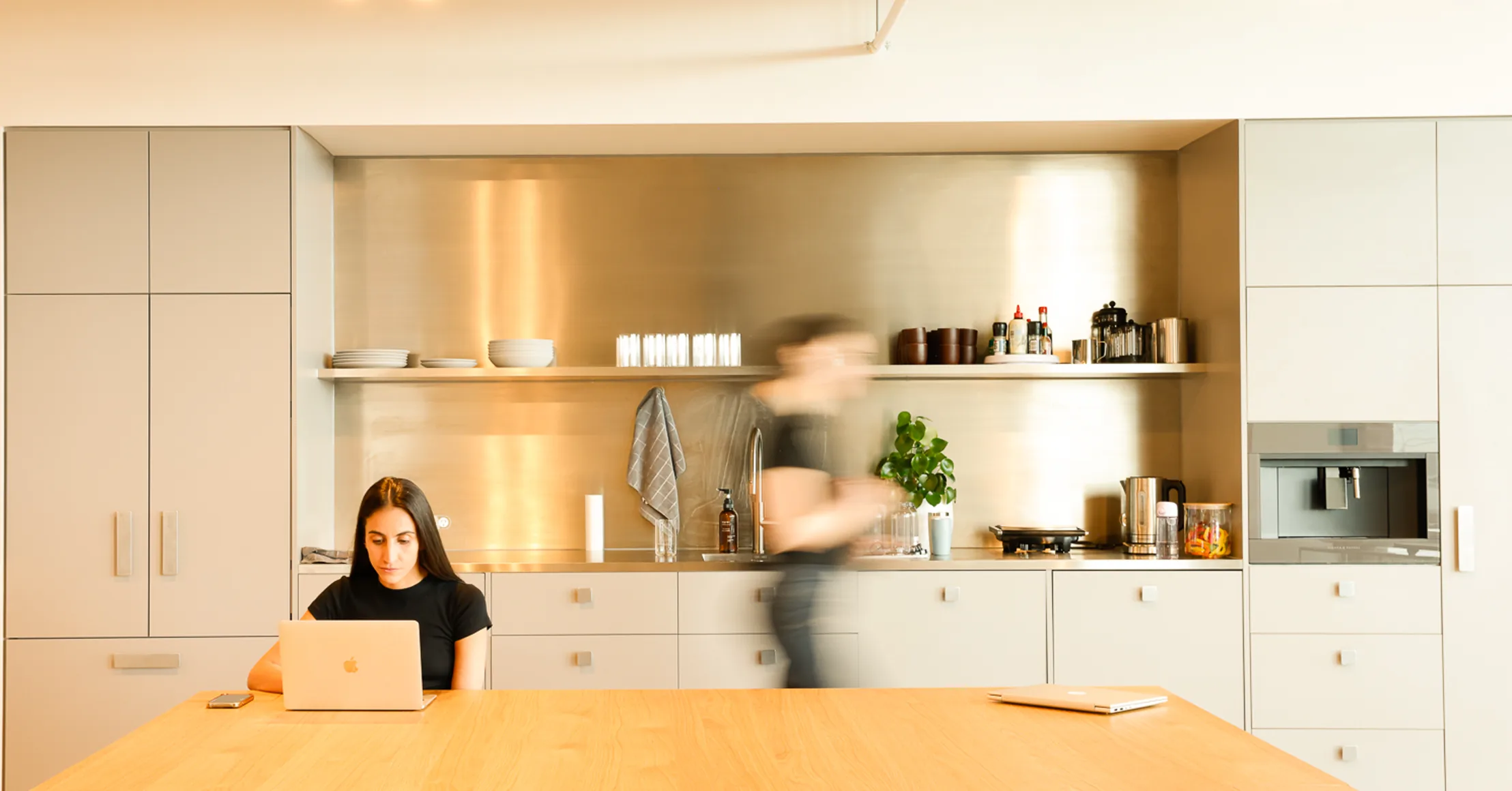 Team member working on a laptop in the office kitchen